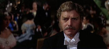 Movie still from “The Leopard” (1963), directed by Luchino Visconti – A person wearing a suit and tie; Close Up shot, Over the shoulder angle