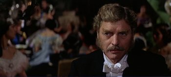 Movie still from “The Leopard” (1963), directed by Luchino Visconti – An older man with a mustache wearing a tuxedo; Close Up shot, Over the shoulder angle