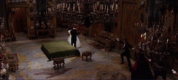 Movie still from “The Leopard” (1963), directed by Luchino Visconti – A man and a woman in wedding attire in a room with chandeliers; Wide shot, High angle