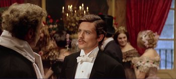 Movie still from “The Leopard” (1963), directed by Luchino Visconti – A man in a tuxedo standing in front of a group of people; Close Up shot, Over the shoulder angle