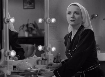 Movie still from “The Leopard Man” (1943), directed by Jacques Tourneur – A black and white photo of a woman in front of a mirror; Medium shot, Over the shoulder angle
