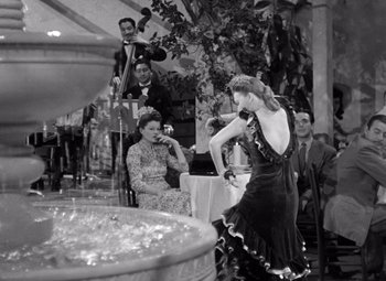Movie still from “The Leopard Man” (1943), directed by Jacques Tourneur – A woman in a black and white photo is dancing; Wide shot, Low angle