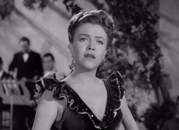 Movie still from “The Leopard Man” (1943), directed by Jacques Tourneur – An old photo of a woman in a black dress; Close Up shot, High angle