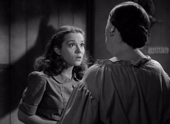 Movie still from “The Leopard Man” (1943), directed by Jacques Tourneur – A woman looking at her reflection in a mirror; Close Up shot, Over the shoulder angle
