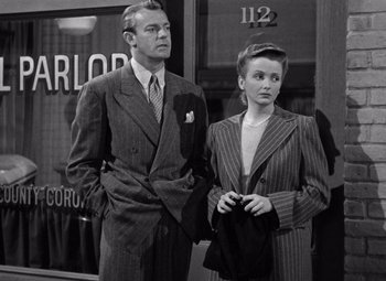 Movie still from “The Leopard Man” (1943), directed by Jacques Tourneur – A man and a woman standing next to each other; Medium shot, Low angle