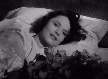Movie still from “The Leopard Man” (1943), directed by Jacques Tourneur – A black and white photo of a woman laying in bed; Close Up shot, High angle