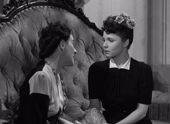 Movie still from “The Leopard Man” (1943), directed by Jacques Tourneur – A couple of women sitting next to each other on a couch; Medium shot, High angle