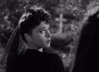 Movie still from “The Leopard Man” (1943), directed by Jacques Tourneur – A black and white photo of a woman in a cemetery; Close Up shot, Over the shoulder angle