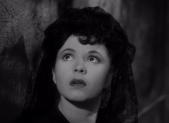 Movie still from “The Leopard Man” (1943), directed by Jacques Tourneur – A woman with a black veil looking upward; Close Up shot, High angle