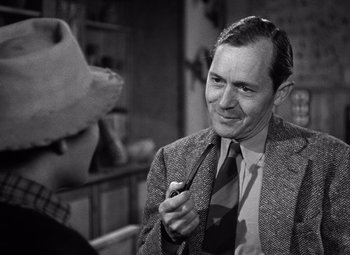 Movie still from “The Leopard Man” (1943), directed by Jacques Tourneur – A black and white photo of a man and a dog; Close Up shot, High angle