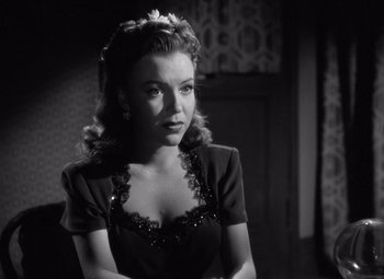 Movie still from “The Leopard Man” (1943), directed by Jacques Tourneur – A woman in a black dress is looking at the camera; Close Up shot, Over the shoulder angle