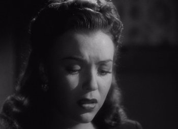 Movie still from “The Leopard Man” (1943), directed by Jacques Tourneur – A black - and - white photo of a woman with a sad look on her face; Close Up shot, Low angle