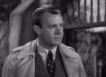 Movie still from “The Leopard Man” (1943), directed by Jacques Tourneur – A man in a trench coat and a tie; Close Up shot, Low angle