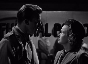 Movie still from “The Leopard Man” (1943), directed by Jacques Tourneur – A man and a woman standing next to each other; Medium shot, Low angle