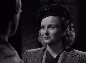Movie still from “The Leopard Man” (1943), directed by Jacques Tourneur – A woman wearing a hat and a suit; Close Up shot, Over the shoulder angle