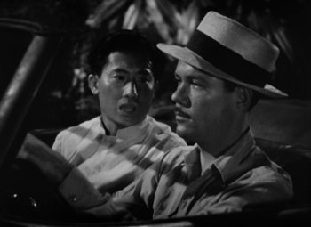 Movie still from “The Letter” (1940), directed by William Wyler – Two men sitting in the back seat of a car; Close Up shot, High angle