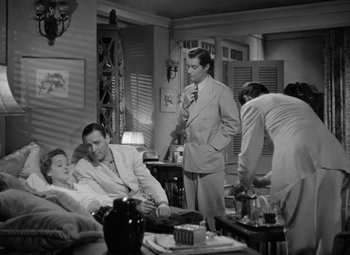 Movie still from “The Letter” (1940), directed by William Wyler – A group of people standing around a living room; Wide shot, High angle