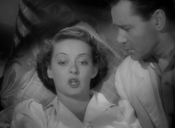 Movie still from “The Letter” (1940), directed by William Wyler – A man and a woman are sitting on the ground; Close Up shot, Overhead angle