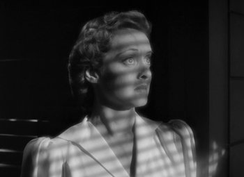 Movie still from “The Letter” (1940), directed by William Wyler – A black - and - white photo of a woman looking up; Close Up shot, Low angle