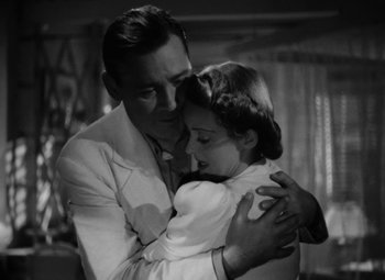 Movie still from “The Letter” (1940), directed by William Wyler – A black and white photo of a man and a woman hugging; Medium shot, High angle