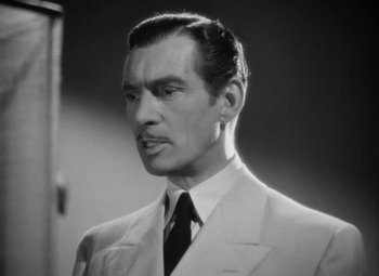Movie still from “The Letter” (1940), directed by William Wyler – Black and white photograph of a man wearing a suit and tie; Close Up shot, Low angle