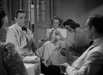 Movie still from “The Letter” (1940), directed by William Wyler – A group of people sitting around a dining room table; Medium shot, High angle