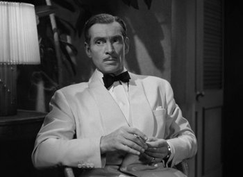 Movie still from “The Letter” (1940), directed by William Wyler – A black and white photo of a man in a tuxedo; Close Up shot, High angle