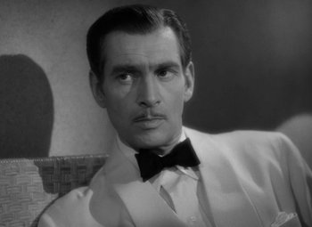 Movie still from “The Letter” (1940), directed by William Wyler – A black and white photo of a man with a bow tie; Close Up shot, High angle