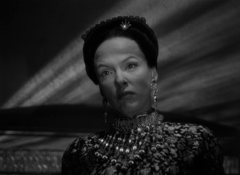 Movie still from “The Letter” (1940), directed by William Wyler – A black and white photo of a woman wearing a hat; Close Up shot, Low angle