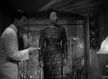 Movie still from “The Letter” (1940), directed by William Wyler – A man and a woman are standing in front of a curtain; Medium shot, Low angle