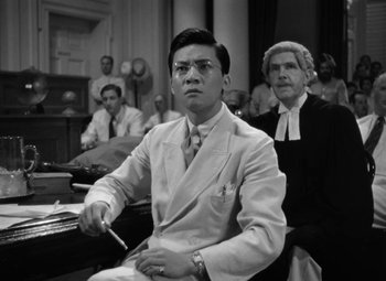 Movie still from “The Letter” (1940), directed by William Wyler – A black and white photo of a man in a courtroom; Medium shot, Low angle