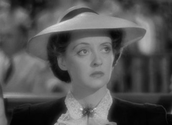 Movie still from “The Letter” (1940), directed by William Wyler – A black - and - white photo of a woman wearing a hat; Close Up shot, High angle
