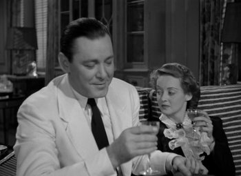 Movie still from “The Letter” (1940), directed by William Wyler – A man and a woman sitting at a table; Medium shot, High angle