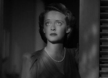 Movie still from “The Letter” (1940), directed by William Wyler – An old photo of a woman in a dress and pearls; Close Up shot, Low angle