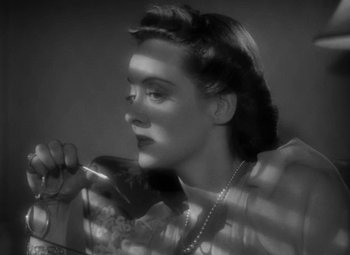 Movie still from “The Letter” (1940), directed by William Wyler – A black and white photo of a woman holding a phone; Close Up shot, High angle