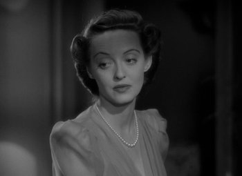Movie still from “The Letter” (1940), directed by William Wyler – An old photo of a woman with a pearl necklace; Close Up shot, Over the shoulder angle