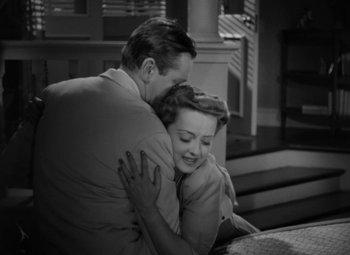 Movie still from “The Letter” (1940), directed by William Wyler – A man and a woman hugging each other; Medium shot, High angle