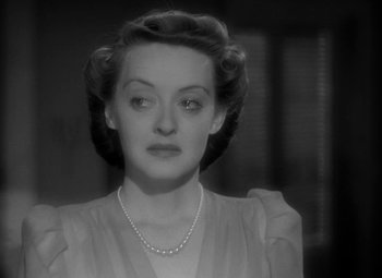 Movie still from “The Letter” (1940), directed by William Wyler – An old photo of a woman with a pearl necklace; Close Up shot, Over the shoulder angle