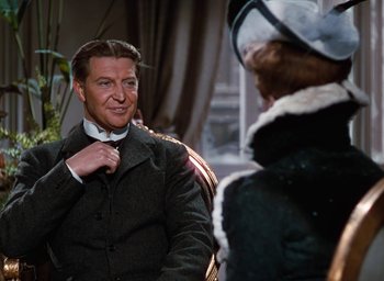 Movie still from “The Life and Death of Colonel Blimp” (1943), directed by Emeric Pressburger – A man adjusting his bow tie while a woman looks on; Medium shot, Over the shoulder angle