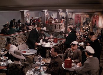 Movie still from “The Life and Death of Colonel Blimp” (1943), directed by Emeric Pressburger – A group of people sitting at tables in a restaurant; Extreme Wide shot, High angle