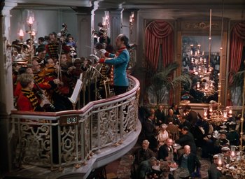 Movie still from “The Life and Death of Colonel Blimp” (1943), directed by Emeric Pressburger – A group of people sitting around a room with candles; Extreme Wide shot, High angle