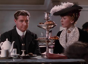 Movie still from “The Life and Death of Colonel Blimp” (1943), directed by Emeric Pressburger – A man and a woman sitting at a table; Medium shot, Over the shoulder angle