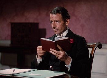 Movie still from “The Life and Death of Colonel Blimp” (1943), directed by Emeric Pressburger – A man sitting at a table reading a book; Close Up shot, High angle