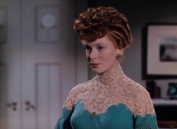 Movie still from “The Life and Death of Colonel Blimp” (1943), directed by Emeric Pressburger – A woman in a blue and white dress with a red hair wig; Close Up shot, Over the shoulder angle