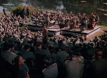 Movie still from “The Life and Death of Colonel Blimp” (1943), directed by Emeric Pressburger – A crowd of people sitting and standing around a stage; Extreme Wide shot, High angle