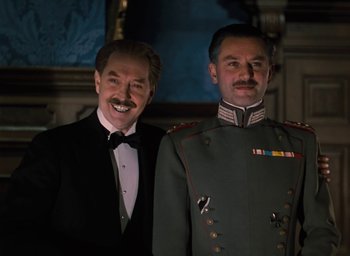 Movie still from “The Life and Death of Colonel Blimp” (1943), directed by Emeric Pressburger – Two men dressed in formal wear posing for a picture; Medium shot, Low angle