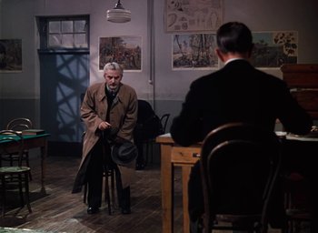 Movie still from “The Life and Death of Colonel Blimp” (1943), directed by Emeric Pressburger – Two men are sitting at a table and one is holding a cane; Wide shot, Over the shoulder angle