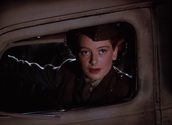 Movie still from “The Life and Death of Colonel Blimp” (1943), directed by Emeric Pressburger – A woman in a military uniform looking out of a window; Close Up shot, Low angle