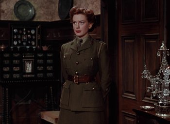 Movie still from “The Life and Death of Colonel Blimp” (1943), directed by Emeric Pressburger – A woman in a military uniform standing in front of a phone booth; Medium shot, Low angle