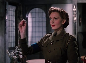 Movie still from “The Life and Death of Colonel Blimp” (1943), directed by Emeric Pressburger – A woman in a military uniform holding a pen; Medium shot, Low angle